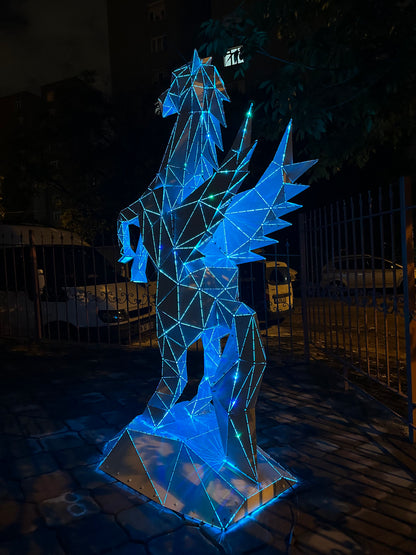 Blue illuminated geometric Pegasus winged horse sculpture made of metal and LED lights at night