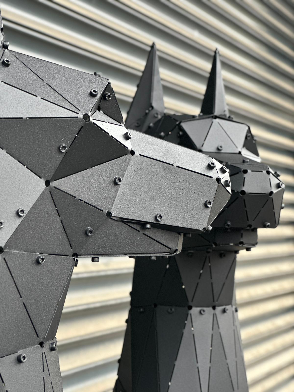 Close-up of a handcrafted geometric black metal Doberman sculpture head with industrial rivets