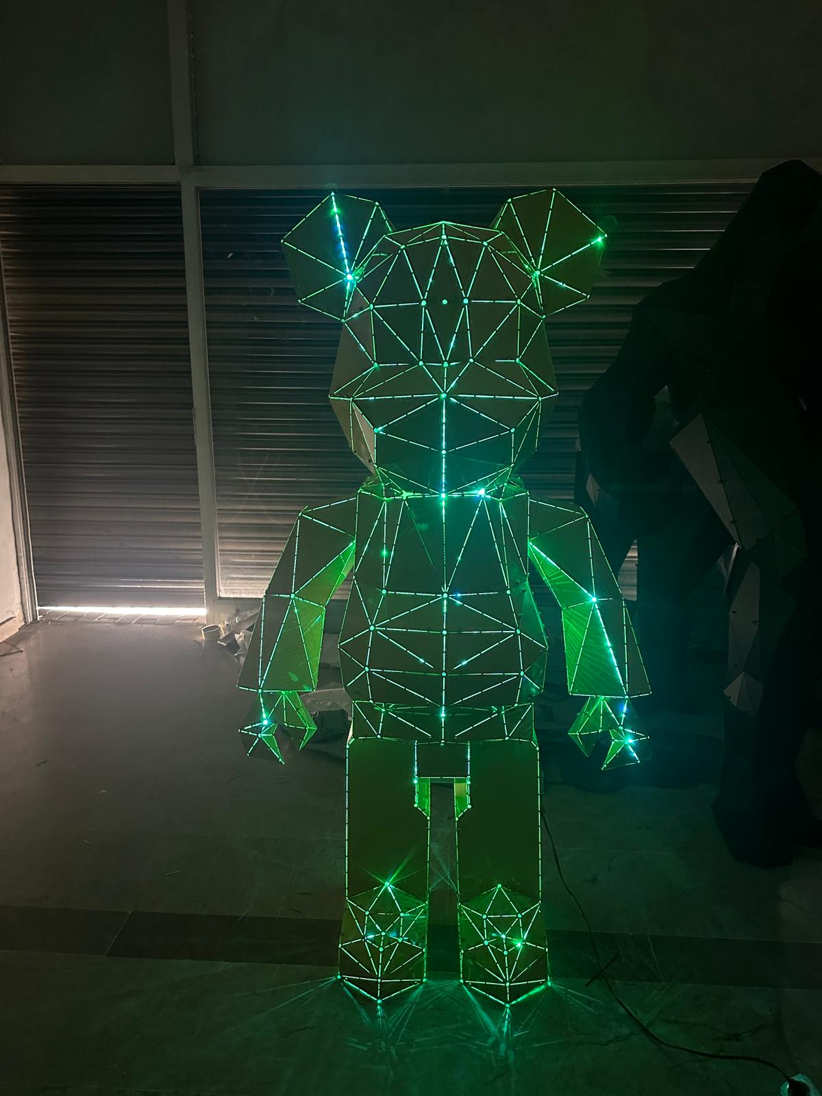 Geometric bear sculpture made of metal wires illuminated with glowing green lights