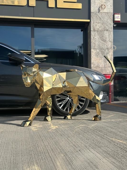 Geometric gold metal panther sculpture standing beside a luxury car