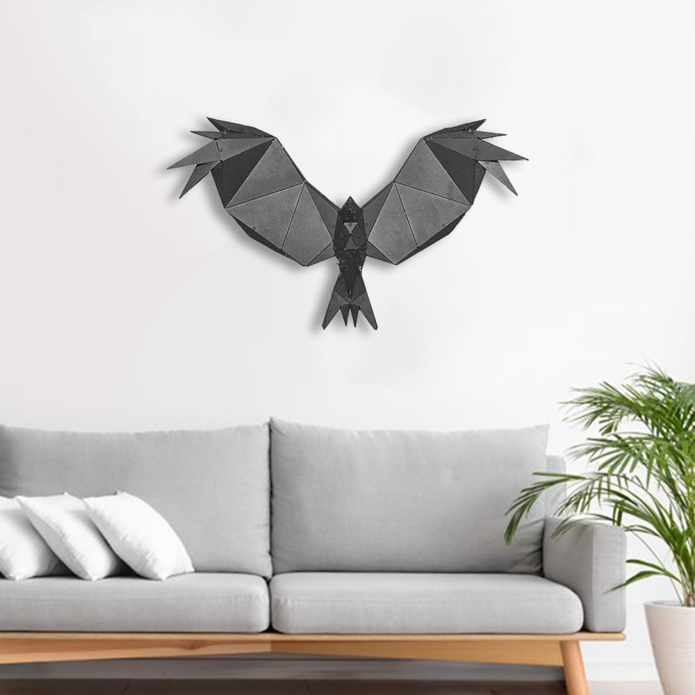 Geometric metal eagle sculpture mounted on a white wall above a grey sofa