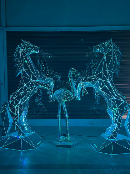 Geometric metal sculptures of horses and a bird illuminated with blue lights