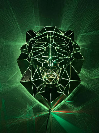 Geometric metal lion head sculpture illuminated by green laser light rays