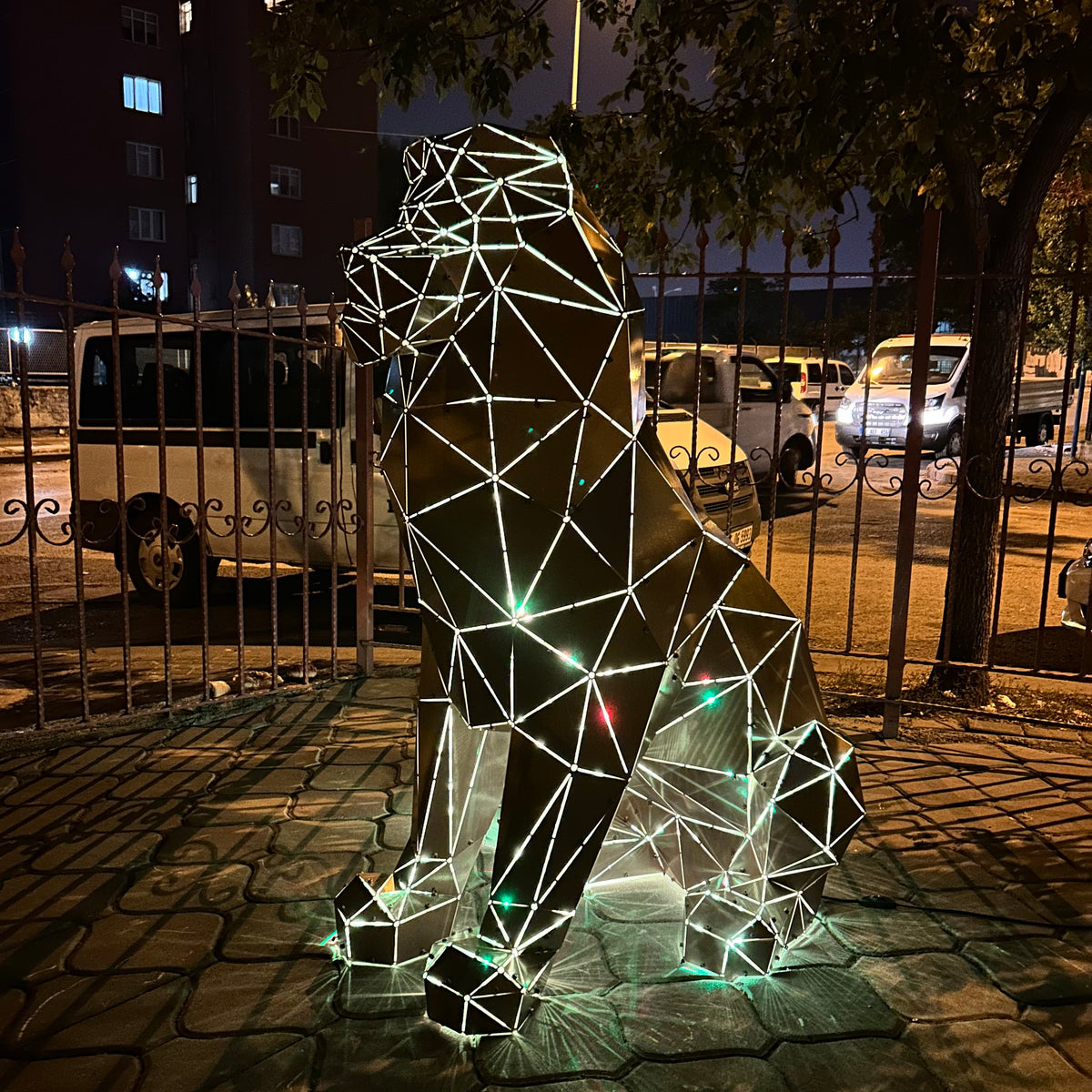 Geometric metal lion sculpture with integrated LED lighting at night