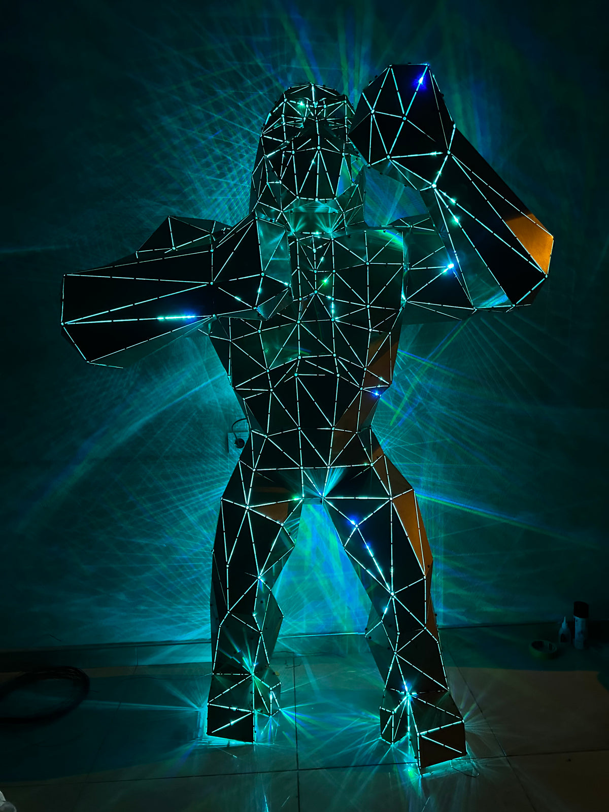 Geometric wireframe gorilla sculpture illuminated by blue and yellow LED lights