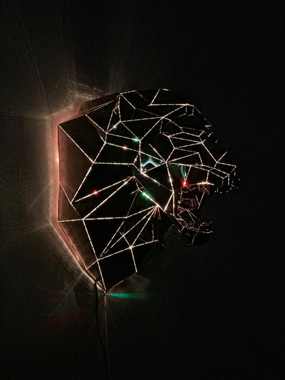 Geometric wireframe sculpture of a lion's head with integrated LED lighting against a dark background
