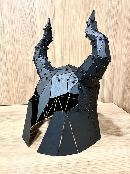 Handcrafted black metal low-poly horned helmet sculpture with raised horns on a wooden surface
