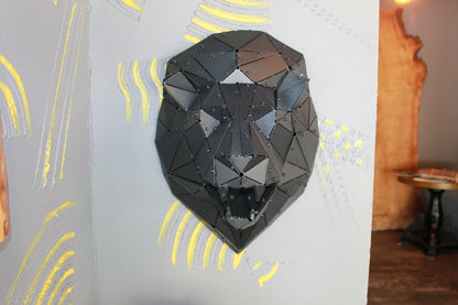 Handcrafted black metal low-poly lion head sculpture mounted on a gray textured wall