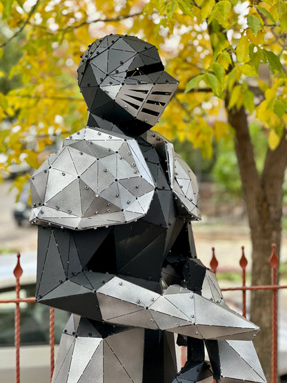 Handcrafted low-poly metal knight sculpture in a garden setting
