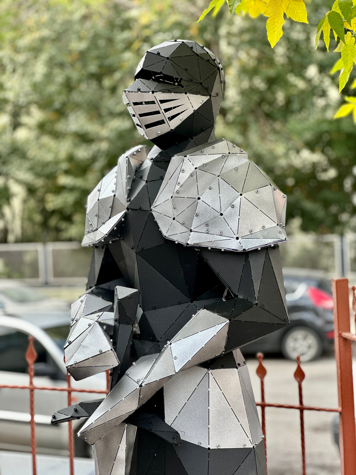 Handcrafted low-poly metal sculpture of a knight in silver and black armor