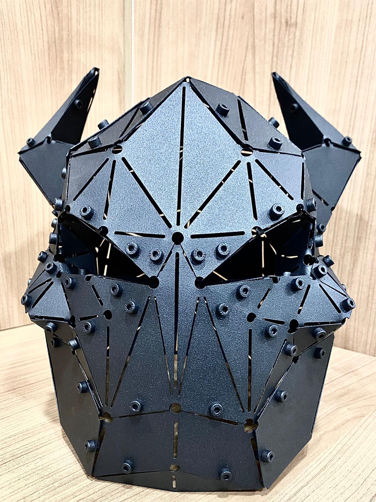 Handcrafted matte black geometric metal mask sculpture with a demonic design