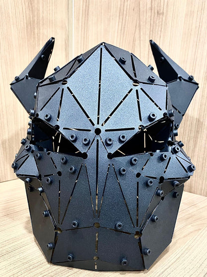 Handcrafted matte black geometric metal mask sculpture with a demonic design