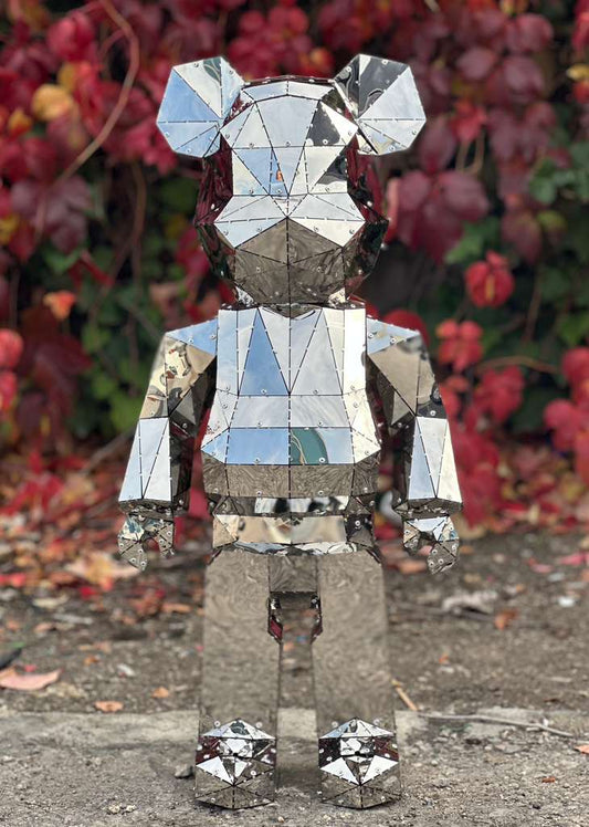 Handcrafted polished mirror-finish metal bear sculpture with geometric facets.