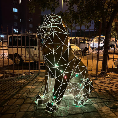 Illuminated geometric metal lion sculpture at night in an urban setting