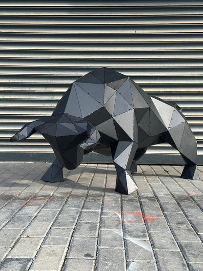 Low-poly black metal bull sculpture on a cobblestone street against a grey shutter.