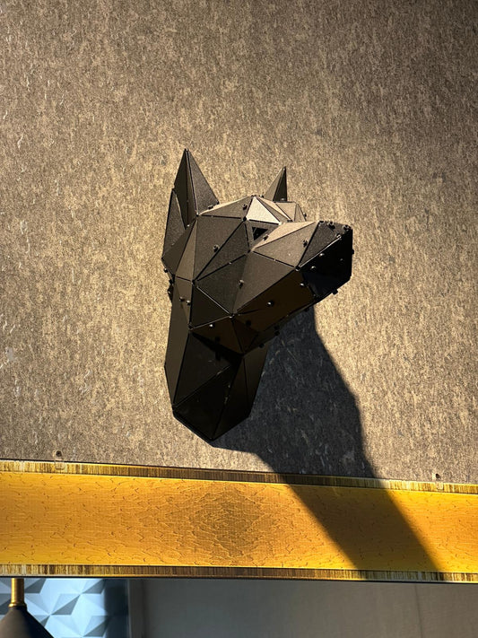 Low-poly black metal Doberman head wall sculpture mounted on a textured grey wall