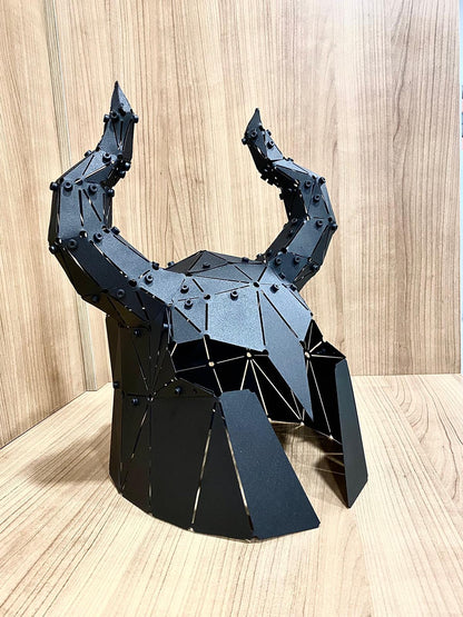 Low-poly black metal horned helmet sculpture, side angle on a wooden surface