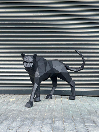 Low-poly black metal panther sculpture standing against a grey industrial shutter background