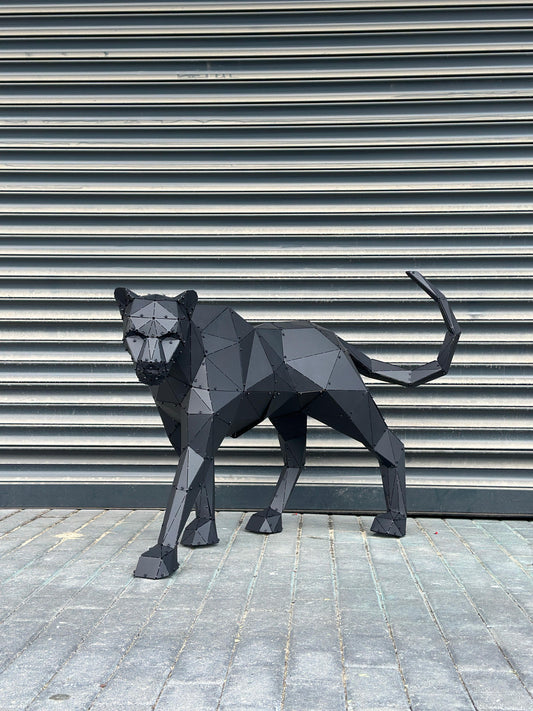 Low-poly black metal panther sculpture standing against a grey industrial shutter background