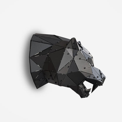 Low-poly black metal tiger head sculpture in side profile on a white background
