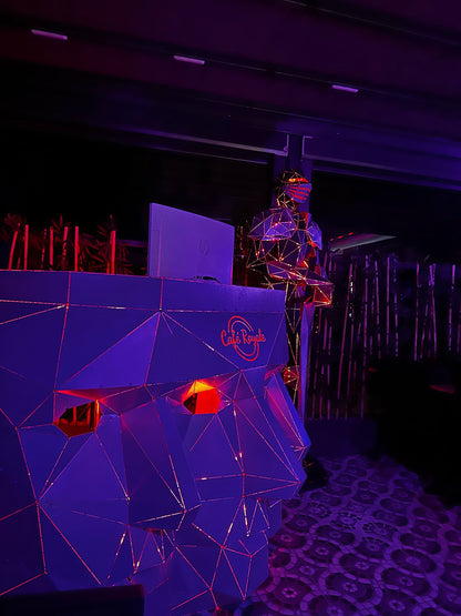 Low-poly geometric metal gorilla sculpture with red neon accents in a dim setting.