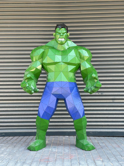 Low-poly metal sculpture of the Hulk in green and blue against a grey shutter background.