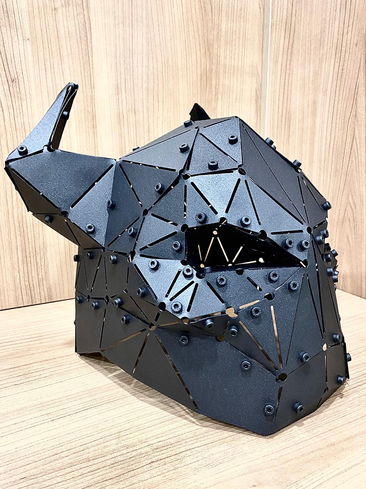 Low-poly handcrafted black metal horned helmet sculpture on a wooden surface, opposite side view
