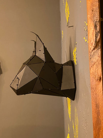 Low-poly handcrafted metal lynx head wall sculpture with tufted ears on a grey wall