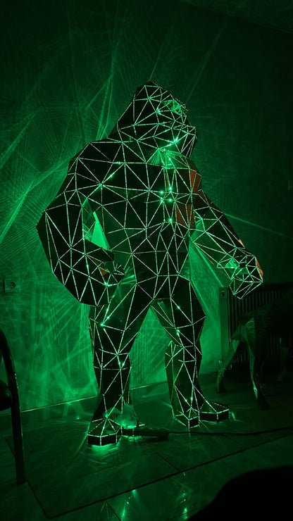 Low-poly metal gorilla sculpture illuminated by green laser lights