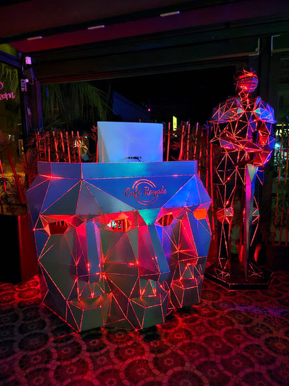 Low poly metal sculpture bar counter with red neon lighting at Café Royale