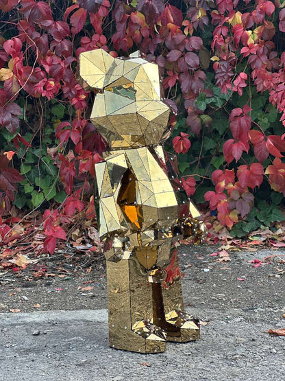 Luxury geometric golden mirror bear sculpture against red autumn foliage