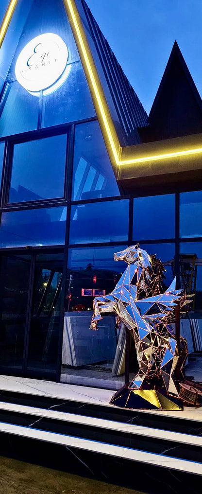 Luxury geometric metal horse sculpture outside a modern building at dusk.