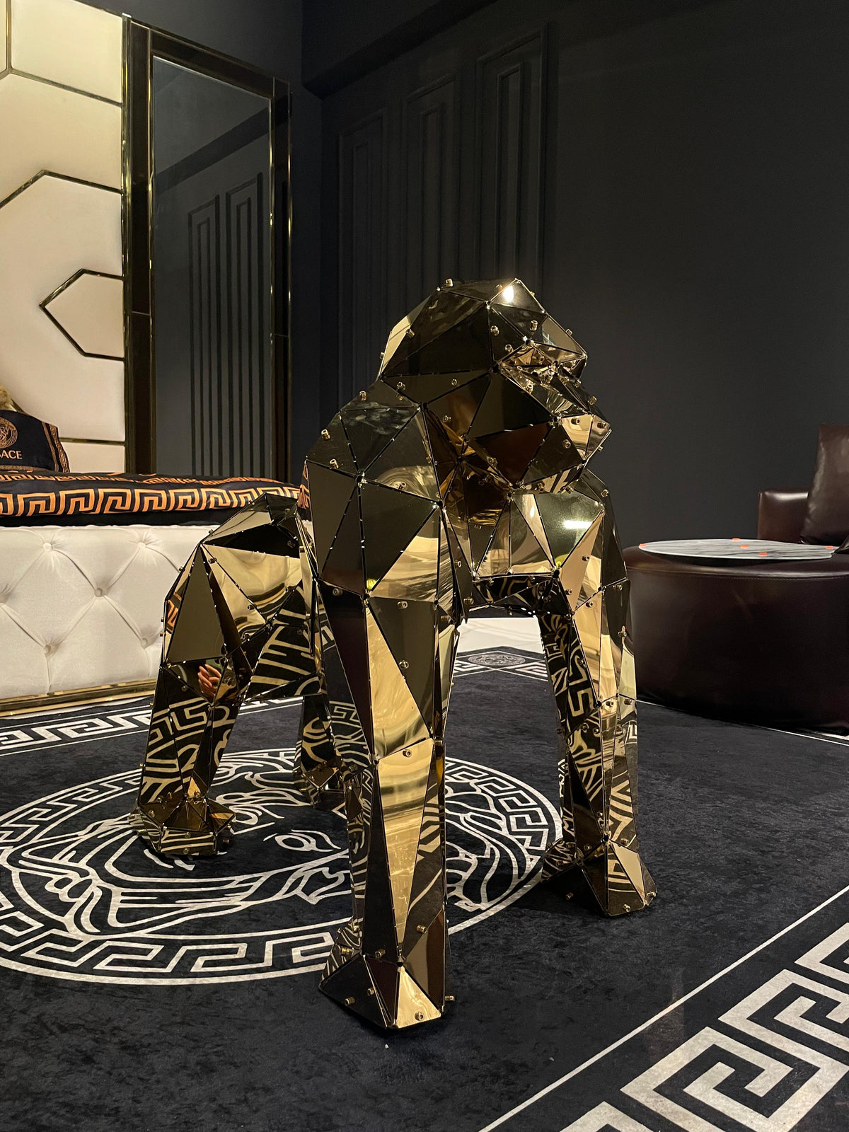 Luxury gold geometric gorilla sculpture on a black and white patterned rug