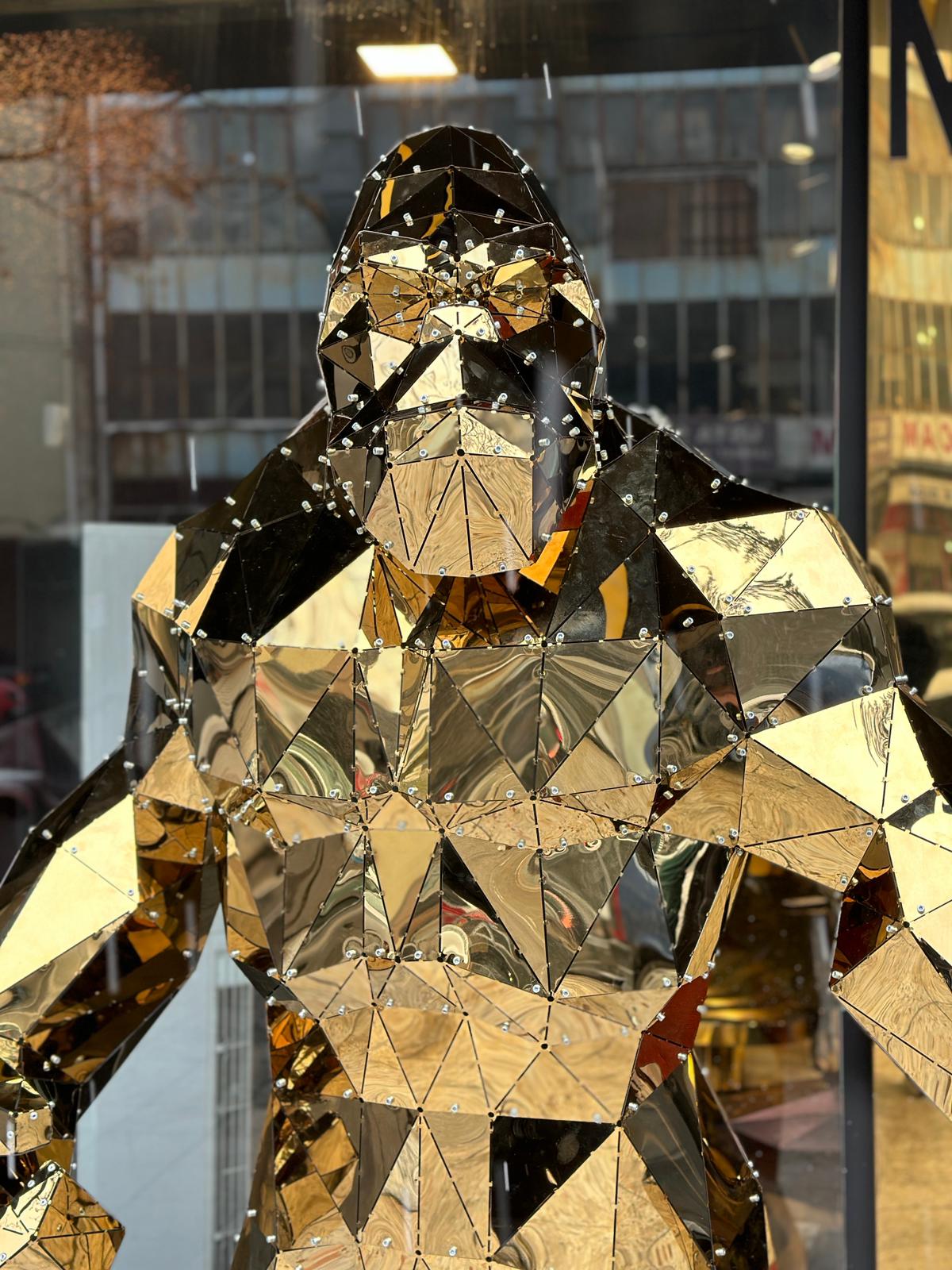 Luxury handcrafted gold faceted metal gorilla sculpture in a store window