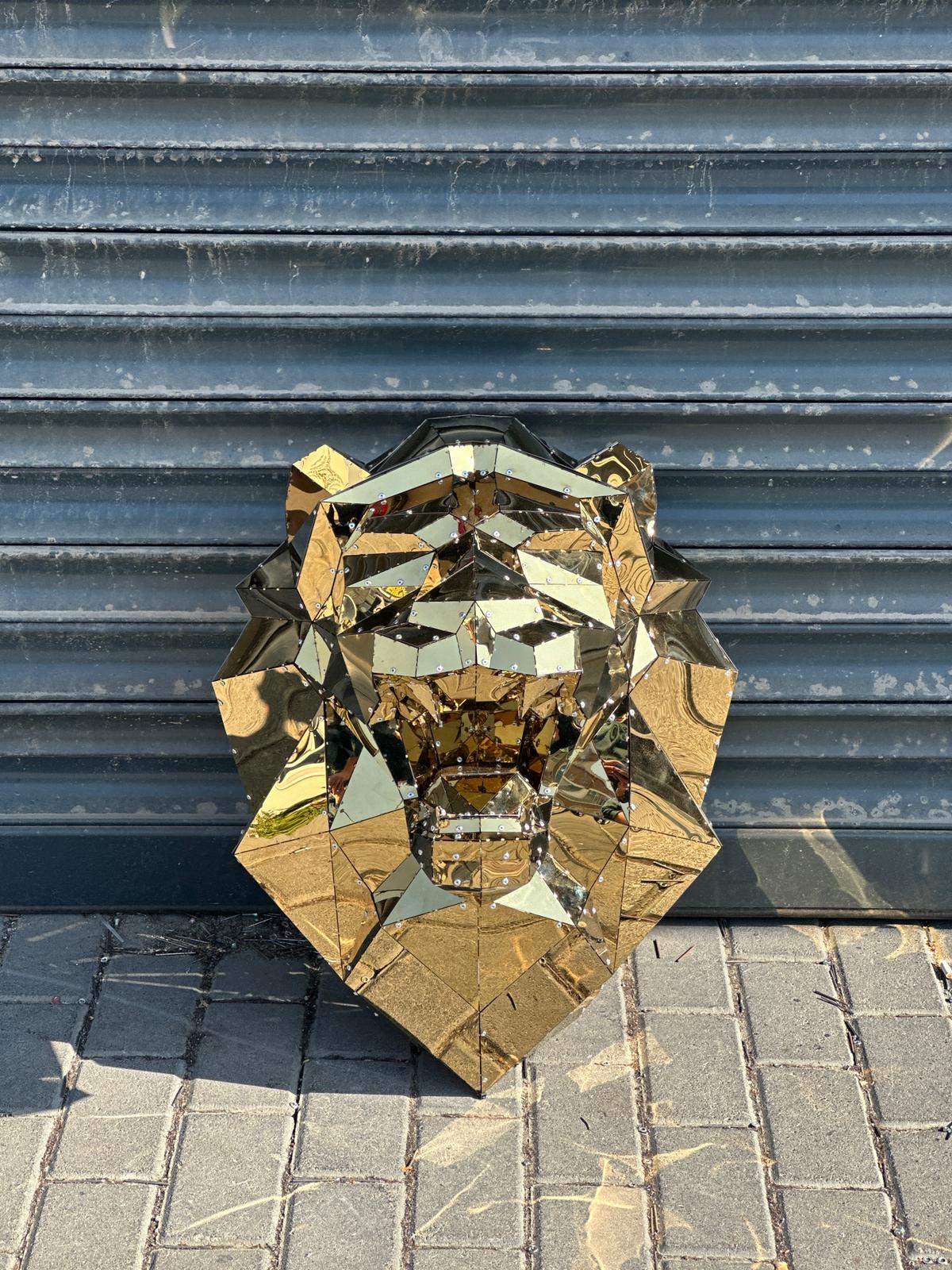 Luxury handcrafted gold geometric lion head sculpture against a grey shutter background