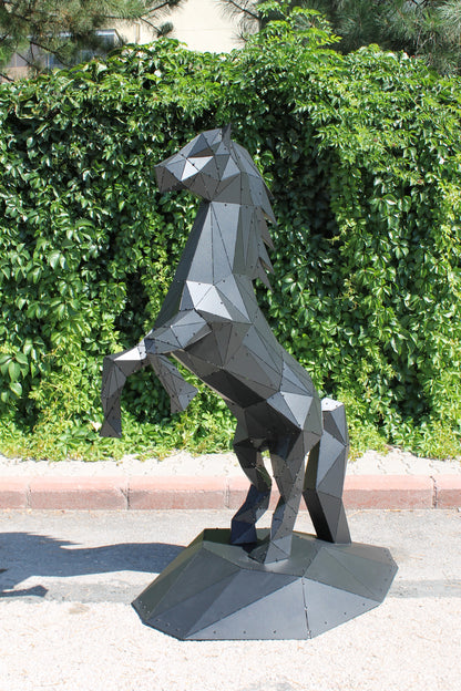 Modern geometric metal sculpture of a rearing horse in matte black against green foliage
