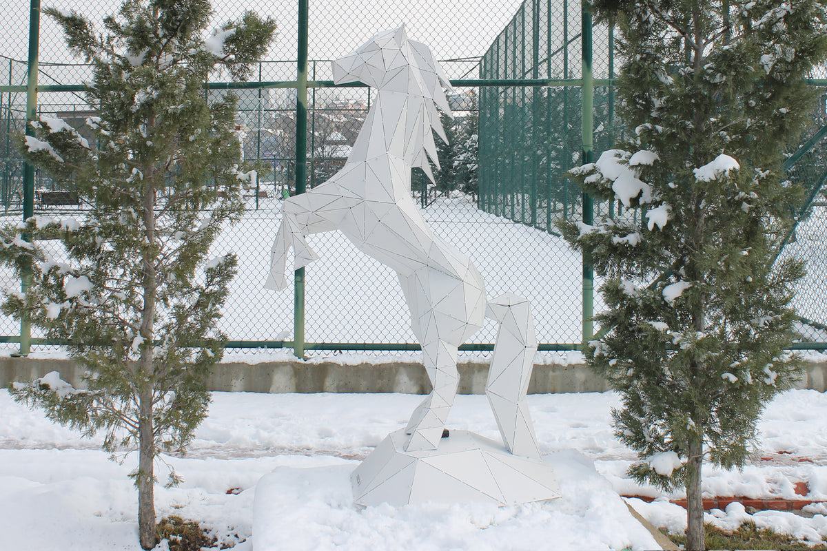 Modern geometric metal horse sculpture in a snowy outdoor setting
