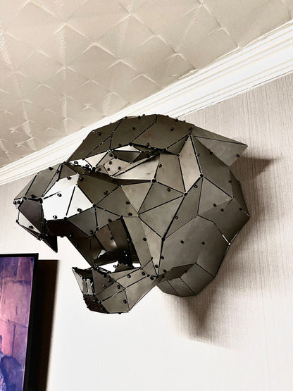 Modern low-poly handcrafted metal panther head sculpture mounted on a white wall.