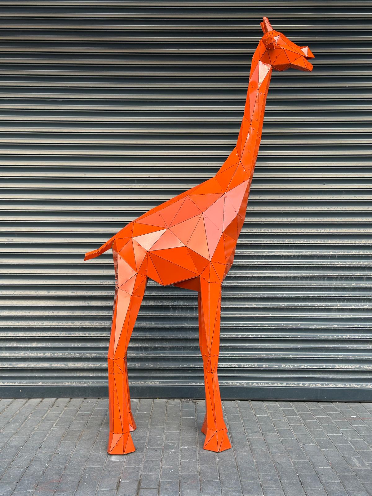 Orange low-poly metal giraffe sculpture against a grey corrugated metal wall