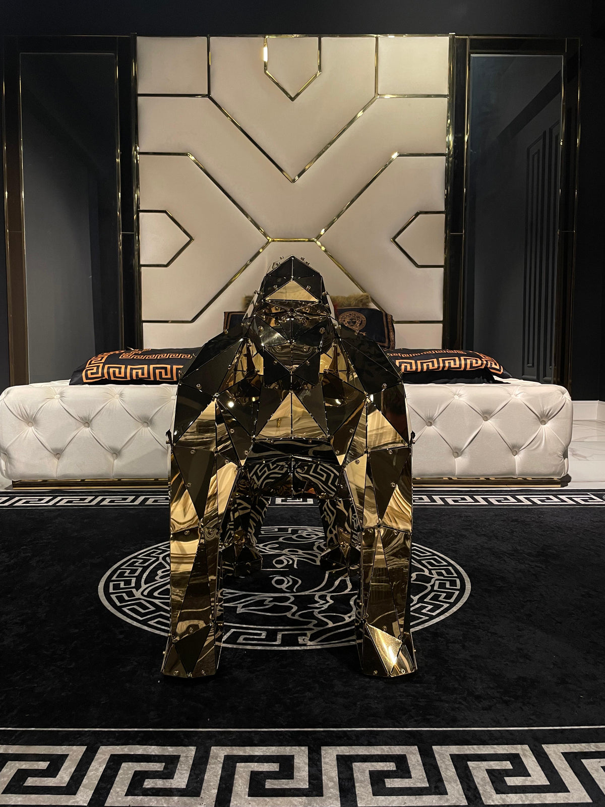 Polished gold geometric gorilla sculpture in a luxury bedroom setting