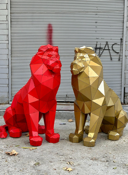 Two geometric metal lion sculptures, one red and one gold, against a grey shutter background.