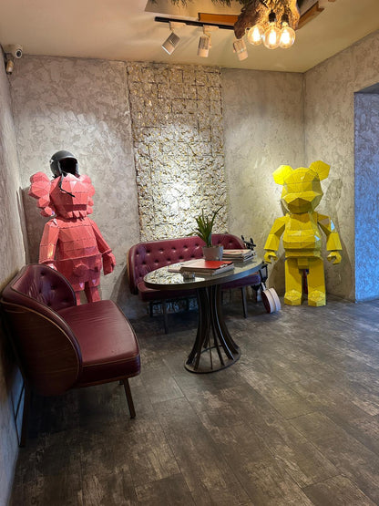 Modern interior with red and yellow handcrafted metal bear sculptures and luxury furniture.