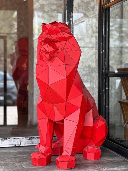 Red low-poly geometric lion sculpture handcrafted from metal