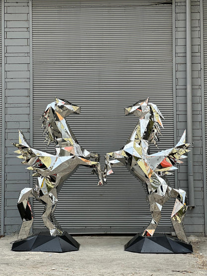 Two mirrored polygonal metal pegasus sculptures facing each other against a grey shutter.