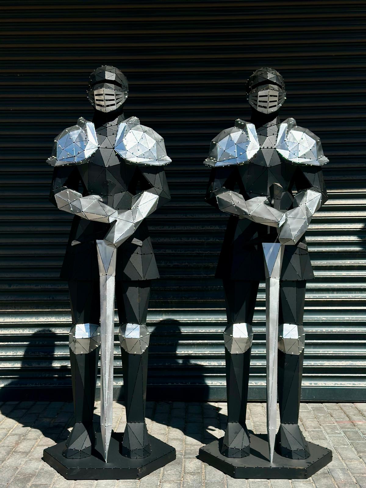 Two modern geometric metal knight sculptures holding swords against a shuttered background.