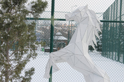 White geometric horse metal sculpture in a snowy outdoor setting